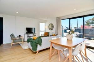 un soggiorno con divano e tavolo di Chatham Street - Christchurch Holiday Homes a Christchurch