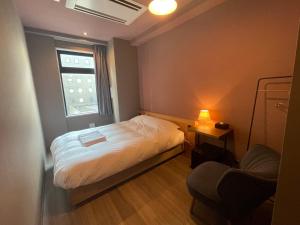 札幌市にあるWISE OWL HOSTELS SAPPOROのベッドと窓のある小さな寝室