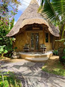 eine kleine Hütte mit einem Strohdach in der Unterkunft Ubud Art Resort in Ubud