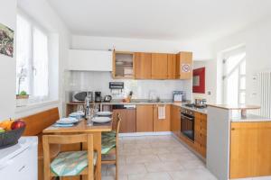 una cocina con armarios de madera y una mesa con sillas. en Casa Palmira, en Drena