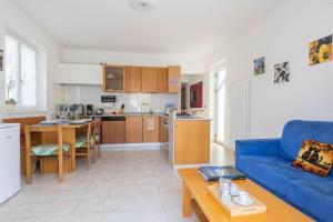 a living room with a blue couch and a kitchen at Casa Palmira in Drena