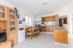 a large kitchen with wooden cabinets and a table at Casa Palmira in Drena