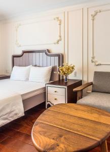 een slaapkamer met een bed met een tafel en een stoel bij Ngan Ha 2 Apartment in Ho Chi Minh-stad