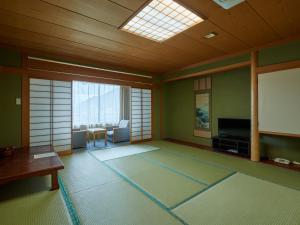 笛吹市にあるTabist Onsen Hotel Toyoの薄型テレビとリビングルームが備わる客室です。
