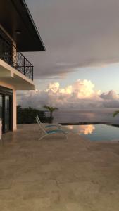 eine Bank auf einer Terrasse neben dem Wasser in der Unterkunft La VILLA MAHOT in Petite Île