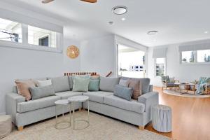 a living room with a gray couch and a table at LEO2-SOPHISTICATED, BEACH HOLIDAY HOME in Alexandra Headland