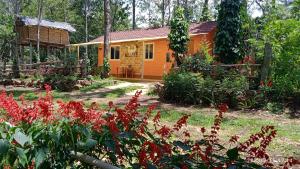 an orange house with red flowers in front of it at farmer homestay yercaud in Yercaud