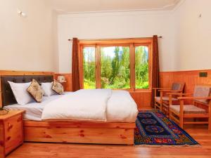 een slaapkamer met een houten bed en een raam bij De Khama in Nubra