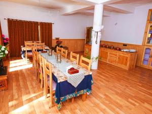 una sala da pranzo con un lungo tavolo e sedie di De Khama a Valle di Nubra