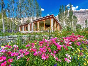 a field of flowers in front of a house at De Khama in Nubra