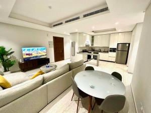 a living room with a couch and a table with chairs at AlYasmin, S&M Luxury Apartment in Riyadh