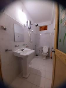 a white bathroom with a sink and a toilet at Artomoro Ceylon motel in Demodera