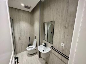 a bathroom with a toilet and a sink and a mirror at AlYasmin, S&M Luxury Apartment in Riyadh +20 photos