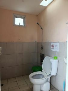 La salle de bains est pourvue de toilettes et d'une fenêtre. dans l'établissement Chacha Homestay & Dormitory, à Ruteng