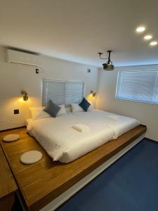 a bedroom with a large white bed with two lamps at Bridge33 CAFE AND HOSTEL in Takagi