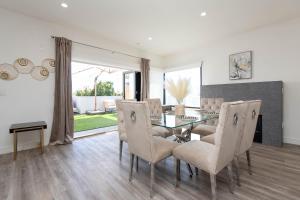 a dining room with a glass table and chairs at Regency Modern Apartments in Los Angeles