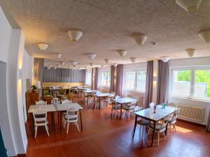 a dining room with tables and chairs and windows at FinKa in Malles Venosta