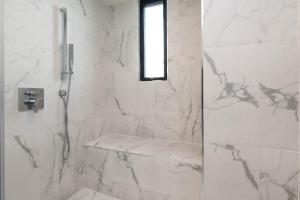 a white bathroom with a shower and a window at Regency Modern Apartments in Los Angeles