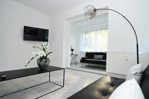 ein Wohnzimmer mit einem Sofa und einem Tisch in der Unterkunft Ferienwohnung & Aparts am Schloss Park in Essen