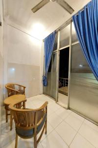 a dining room with a table and chairs and a window at Hotel Serasi 2 in Tangerang