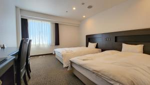 A bed or beds in a room at Platon Hotel Yokkaichi