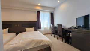 una camera d'albergo con due letti e una scrivania con televisore di Platon Hotel Yokkaichi a Yokkaichi Altre 37 foto