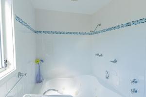 Coral Cottage في Berrara: حمام أبيض مع حوض استحمام ومغسلة +10 صور