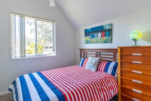 Coral Cottage في Berrara: غرفة نوم بسرير وخزانة ونافذة