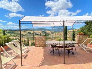 a patio with a table and chairs under a canopy at Agriturismo San Tommaso in Pomarance