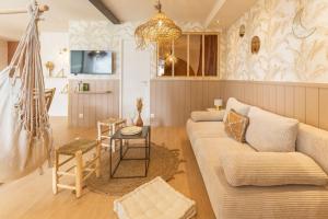 - un salon avec un canapé et une table dans l'établissement Les Voiles - Appart'hotel "Le Suroit", à Carnac