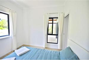 a bedroom with a blue bed and a window at Hilltop Retreat - best of both worlds: Beach/farm in Pillar Valley