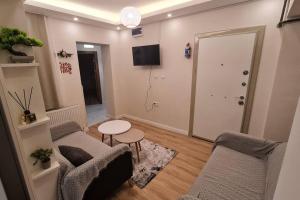 a living room with two chairs and a table and a television at Cozy 2 bedroom near Green Mosque in Yıldırım