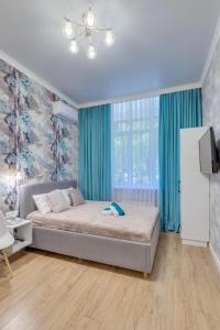 - une chambre avec un grand lit et des rideaux bleus dans l'établissement Asaapart Vernyi Room 1, à Almaty