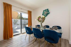 a dining room with a table and blue chairs at Regency Modern Apartments in Glendale
