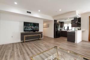 a living room with a television on a wall at Regency Modern Apartments in Glendale
