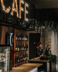 een vrouw die aan een toonbank in een wijnwinkel staat bij ibis Tallinn Center in Tallinn