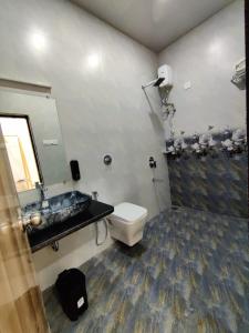 a bathroom with a toilet and a sink and a mirror at Resort - Toms Hideout in Mumbai