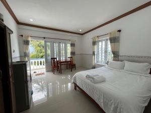 a bedroom with a bed and a table and chairs at I Hostel Muine - A Little White Homestay By The Sea in Ấp Thiện Long
