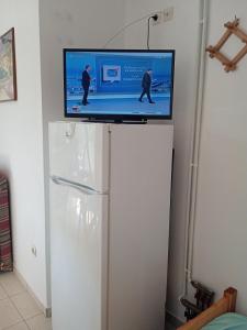a flat screen tv on top of a refrigerator at Σπίτι στο βουνό αλλά μια ανάσα από τη θάλασσα in Palaiokhórion