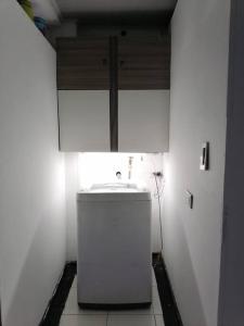 a white bathroom with a sink and a cabinet at Disfruta tu estancia en Pereira! in Pereira