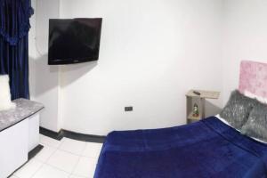 a bedroom with a bed and a flat screen tv at Disfruta tu estancia en Pereira! in Pereira