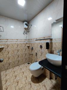 a bathroom with a white toilet and a sink at Resort - Toms Hideout in Mumbai