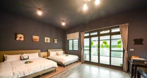 a bedroom with two beds and a large window at Happy Dog Homestay in Hualien City
