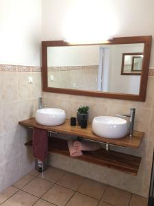 a bathroom with two sinks and a mirror at Au domaine du vacoa in Saint-Philippe