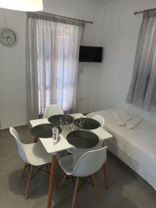 アリキにあるHolidays in Parosのテーブル、椅子、ベッドが備わる客室です。