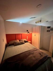 een slaapkamer met een groot bed met een rood hoofdeinde bij Departamento TAPO/Aeropuerto in Mexico-Stad