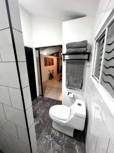 een badkamer met een wit toilet en een wastafel bij Departamento TAPO/Aeropuerto in Mexico-Stad