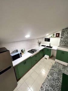 a kitchen with green cabinets and white counter tops at Departamento TAPO/Aeropuerto in Mexico City