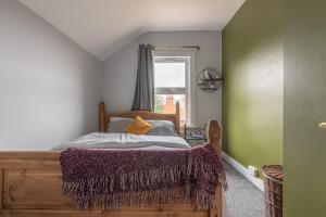 a bedroom with a bed with a wooden frame and a window at Large 5 bed 2 bath House - Free Parking - Reading Cent - Perfect for long contractor stays in Reading
