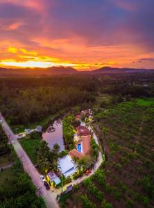 een luchtzicht op een huis en een rivier bij zonsondergang bij Colorful Pool Villa in Ban Chin Tham Mai